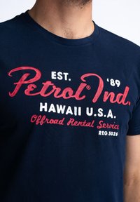 Navy blue cotton t-shirt featuring red and white text: "Petrol Ind. EST. '89 HAWAII U.S.A. Offroad Rental Service REG.5026."