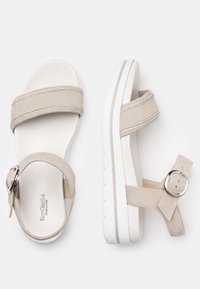 Sandalias de ante beige que presentan dos tiras anchas con detalles decorativos, una hebilla circular y una gruesa suela de goma blanca.