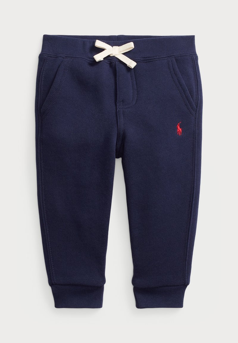 Los pantalones de chándal azul marino presentan una textura suave, una cinturilla elástica con un cordón color crema, bolsillos laterales y un pequeño logo rojo en el muslo.