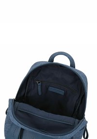 Zaino in tessuto blu con una superficie testurizzata, tasca con zip all'interno e manico superiore. Foderato con tessuto scuro, dotato di una zip liscia.