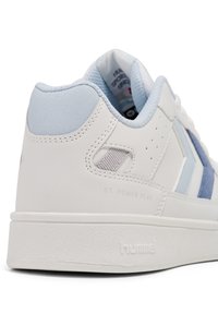 Bílé tenisky se světle modrými detaily, vyrobené z kůže a semiše. Mají strukturovanou bílou podrážku, perforované části a logo značky.