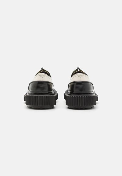 Schwarze Plateauschuhe mit einem glänzenden Lackleder-Obermaterial und einer gerippten Gummisohle. Verfügt über ein schlupfbares Design und minimalistische Nähte.