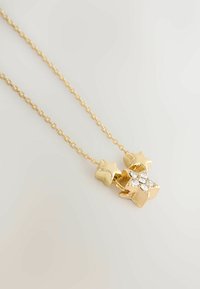 Złoty naszyjnik z zawieszką w kształcie dwóch gwiazdek, jedna gładka, a druga ozdobiona małymi przejrzystymi kryształkami, na delikatnym łańcuszku.