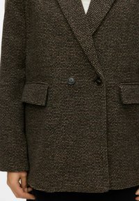 Rjav teksturiran blazer z nežnim karo vzorcem, z zareznim ovratnikom, dvema gumboma in poševnimi sprednjimi žepi.