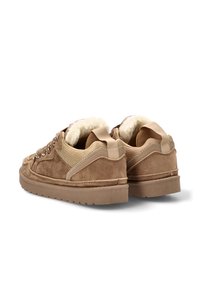 Zapatillas de ante marrón con un acabado texturizado, interior forrado de piel, suelas planas y tiradores en bucle en la parte posterior. Ojetes de metal para los cordones.