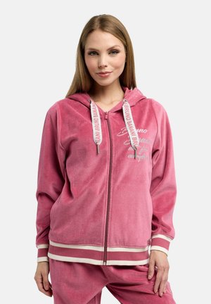 Pink zip-up hoodie i blødt, tekstureret stof med hvide stribede detaljer og trykt tekst. Har hætte og en afslappet pasform.