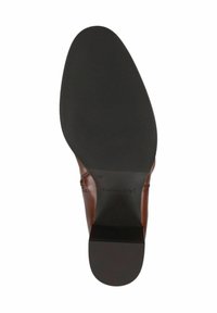 Semelle en cuir marron, présentant un dessous en caoutchouc noir texturé avec des rainures horizontales, et le logo "CAPRICE" près du centre.