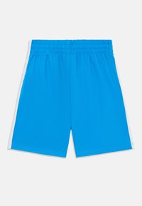 Shorts de sport bleus avec une taille élastique, dotés de rayures blanches sur les côtés, fabriqués en tissu léger, présentant une texture lisse.