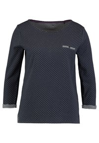 Navy long-sleeved shirt with white polka dots, crew neckline, and striped cuffs. Features a small chest pocket with decorative accents.