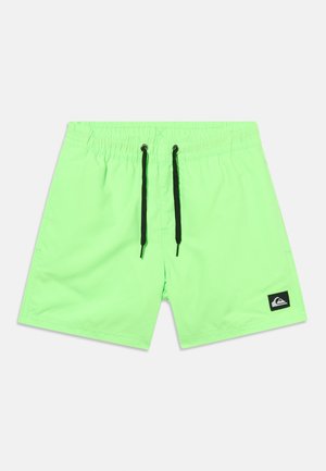 Pantalones cortos de baño de color verde brillante con cordón ajustable negro y pequeño parche con logo negro en la pierna izquierda sobre un fondo blanco.