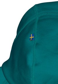 Blågrøn sweatshirt med hætte, synlige søm, og et lille svensk flagmærkat på siden. Glat stoftekstur.