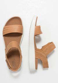 Sandali in pelle marrone con suole in gomma bianca, caratterizzati da due larghe cinghie superiori e una cinghia posteriore regolabile per una vestibilità sicura.