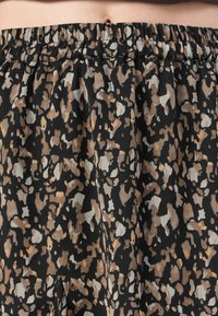 Schwarze knöchellange Rock mit einem gerafften Taillenbund. Besitzt ein Leopardenmuster in Brauntönen, Creme und Schwarz. Leichtes, strukturiertes Material.