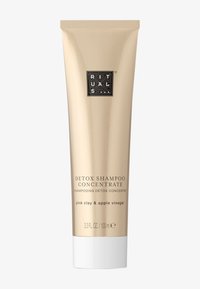 Tube doré de concentré de shampooing détox avec un capuchon blanc, étiqueté « argile rose & vinaigre de pomme ». Logo noir près du haut, design minimaliste.