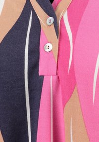 Puuvillapaita, jossa on vaaleanpunainen, tummansininen ja beige abstrakti kuvio. Paidassa on napillinen pääntie hopeisilla yksityiskohdilla ja teksturoitu kangaspinta.