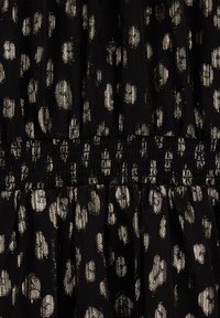 Crni materijal s zlatnim leopard mrljama i teksturiranim smotanom pojasom. Mekan, lagan materijal s lepršavim siluetom.