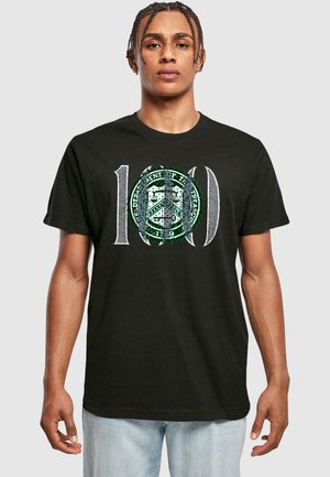 Sort bomulds T-shirt med et stort "100" grafik i hvid og grøn, med et cirkulært designelement i midten. Korte ærmer.