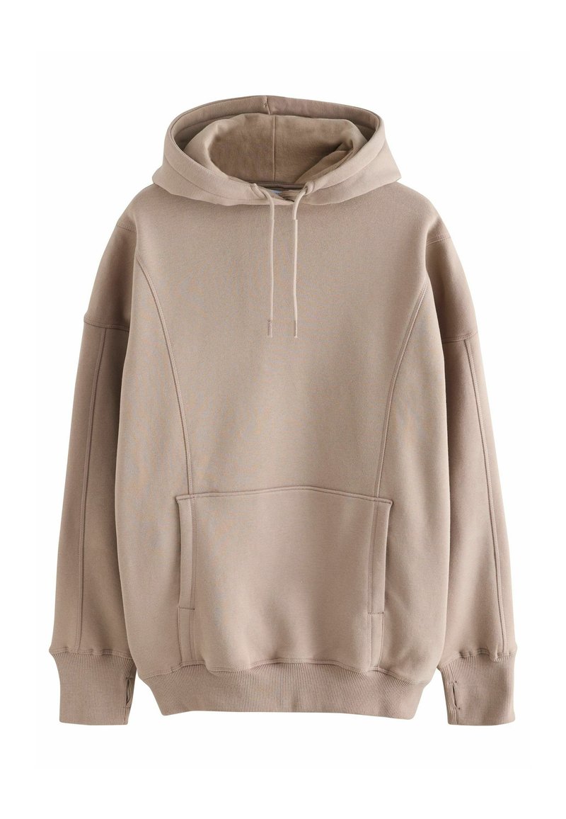 Hoodie beige surdimensionné fabriqué en tissu doux. Il présente une grande poche kangourou, des poignets côtelés et une capuche avec cordon de serrage. Texture lisse.
