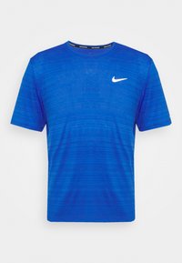Modré sportovní tričko s krátkým rukávem, s texturovaným vzorem, kulatým výstřihem a malým bílým logem Nike na levé hrudi.