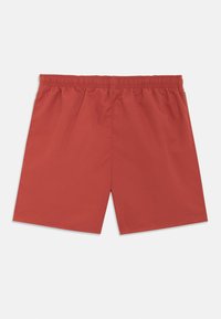 Calções de banho vermelhos com cintura elástica, feitos de tecido leve, com textura suave e ajuste folgado. Sem bolsos visíveis.