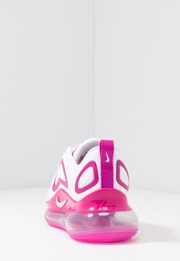 Baskets Nike blanches et roses avec un dessus en maille respirante, des découpes distinctes et une grande semelle à air transparente.