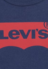 Maglietta navy con un grande logo rosso di Levi's caratterizzato da un design curvo, realizzata in cotone con colletto a girocollo a coste e una texture morbida.