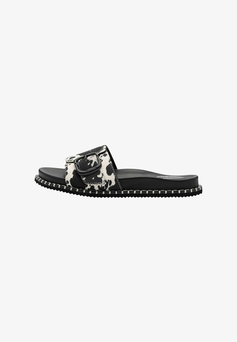 Sandales à enfiler à imprimé vache noir et blanc avec une large bride, détail avec boucle, semelle plate et semelle extérieure texturée pour une meilleure adhérence.