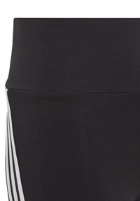 Leggings sportivi neri con un design aderente, texture liscia e tre strisce bianche lungo il lato per un tocco di dettaglio in più.