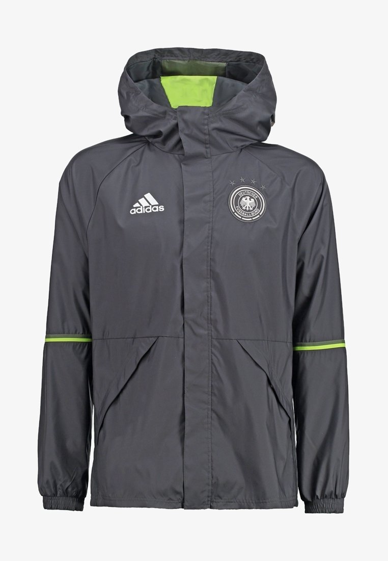 Giacca a vento Adidas grigia con fodera verde, dotata di zip frontale, cappuccio regolabile e logo con emblema sul petto.