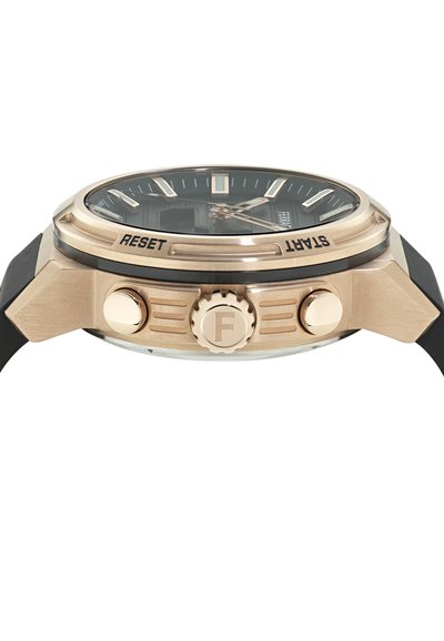 Käekell külgvaates roosa kulla korpuse, musta sihiku, kahe nupuga, millel on silt "RESET" ja "START", ning musta kummirihmaga.