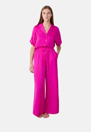 Roze twee-delige outfit met een kortärmige overhemd met knopen en wijde broek met elastische tailleband en koord. Soepele textuur.