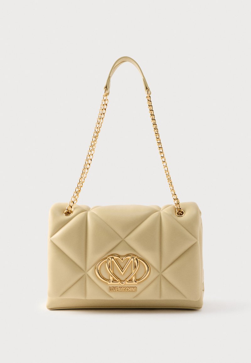 Υφασμένο μπεζ τσάντα από μαλακό υλικό, με χρυσή αλυσίδα ως λουρί και ανάγλυφο λογότυπο μπροστά, με καπιτονέ σχέδιο.