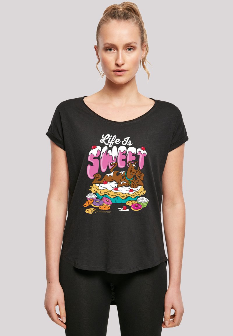 Svart t-skjorte med korte ermer som har en fargerik grafikk med teksten "Livet er søtt", som viser dessertvarer som kake og småkaker.