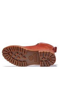 Červená kožená kotníková bota s gumovou podrážkou. Obsahuje boční zip a texturovaný vzor na podrážce pro lepší přilnavost. Logo Timberland na podrážce.