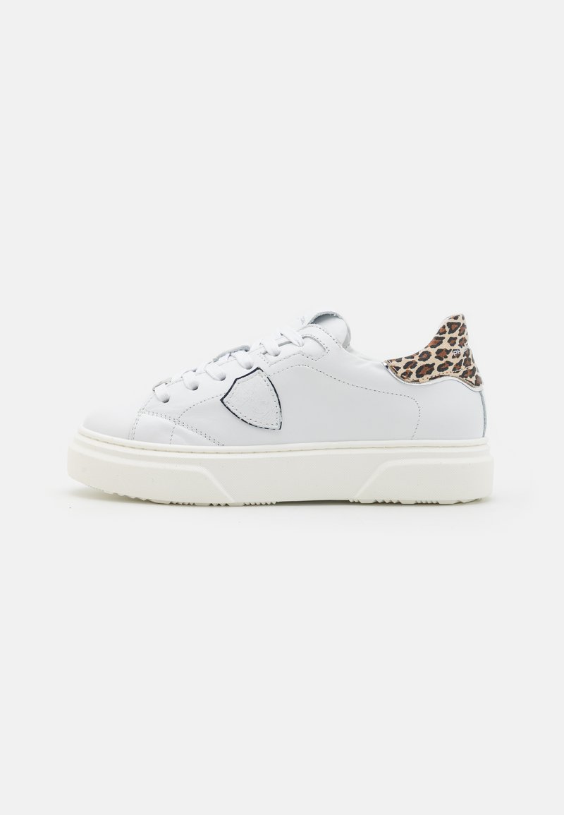 Sneaker bianchi a collo basso con suola spessa, chiusura con lacci, emblema a scudo sul lato e dettaglio in stampa leopardata sul colletto del tallone.