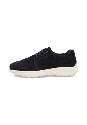 Zapatilla deportiva casual de ante negro con cordones azul marino y suela gruesa de goma blanca, mostrada de perfil sobre un fondo blanco.