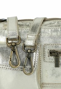 Metallisch graue Handtasche mit glatter Textur, ausgestattet mit zwei bronzefarbenen Verschlüssen und einer Reißverschlusstasche. Sichtbare Steppnähte und Logo.