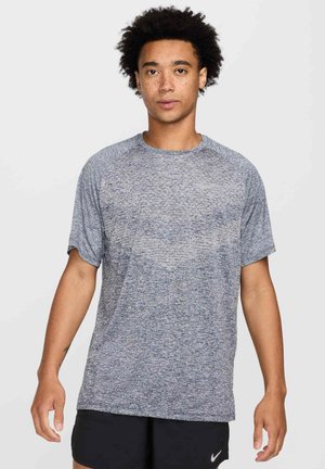 Graues Sport-T-Shirt mit kurzen Ärmeln, das eine melierte Textur und einen runden Ausschnitt aufweist. Dezentes Logo auf der Brust.