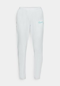 Klasické teplákové kalhoty Nike, světle šedá tkanina, zúžený střih, elastický pas, tyrkysové logo na levé straně, hladká textura, bez kapes.