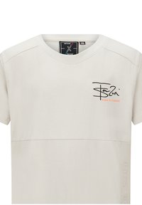 Lichtgrijze t-shirt van zachte stof met een ronde hals, korte mouwen en een zwarte tekstafdruk met oranje accent op de linkerkant van de borst.