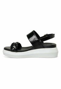 Sandal de charol negro con banda frontal trenzada, correa ajustable en el tobillo y plantillas texturizadas. Suela de plataforma blanca elevada.