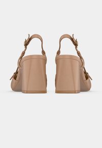 Sandales à plateforme nude avec talons blocs, dotées de brides ajustables à la cheville et de détails tissés sur les brides pour une texture supplémentaire.