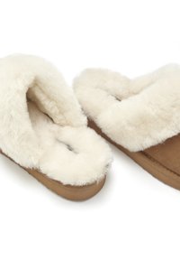 Tan suede slippers featuring a fluffy cream faux fur lining and a soft, comfortable sole. Open design with a rounded toe.