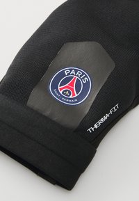 Czarna rękawica termiczna z teksturowanej tkaniny, dopasowanego kroju oraz szytym mankietem. Zawiera okrągłe logo Paris Saint-Germain.