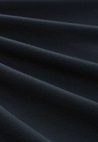 Tissu sombre avec une texture lisse, présentant de multiples plis et une couleur unie, sans motifs ni accents.