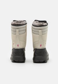 Bottes de neige imperméables beige avec un doux revêtement de fourrure grise, des sections de cheville rembourrées et des semelles en caoutchouc noir avec un design texturé.