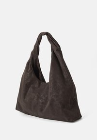 Sac hobo marron foncé en cuir texturé doux avec une anse torsadée et un design ample et décontracté, présentant des contours lisses et des détails minimalistes.