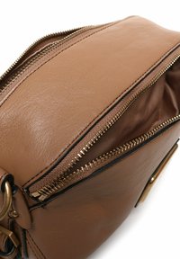 Borsa a mano in pelle marrone con dettagli della cerniera dorati. L'interno è in tessuto beige. Presenta una texture liscia con una silhouette strutturata.