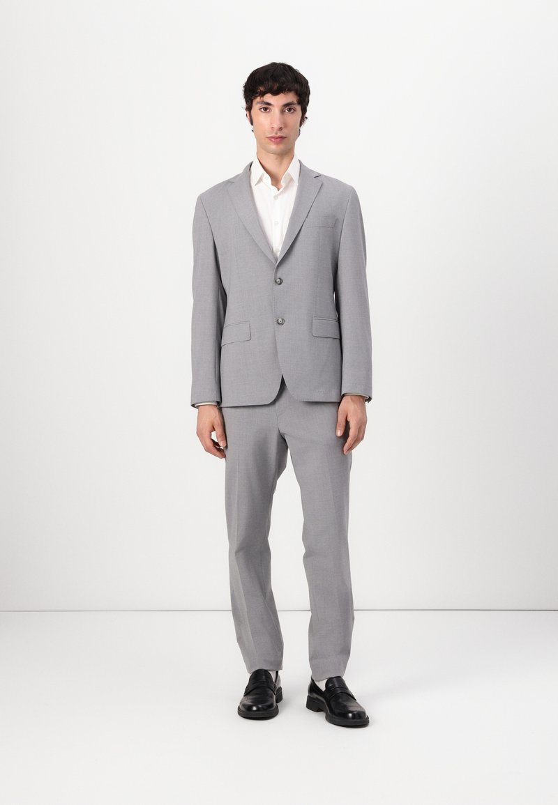 Grey two-piece suit made from textured fabric, featuring a single-button blazer and straight-leg trousers, paired with black shoes.