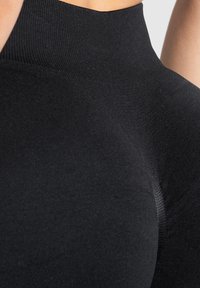 Top nero a collo alto realizzato in tessuto elasticizzato, con una texture liscia, silhouette aderente e dettagli di cucitura sottili.